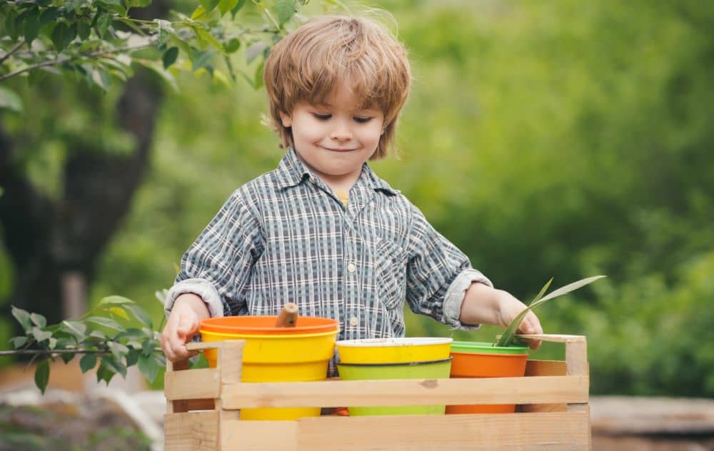 Child holding colorful pots.